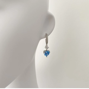 Boucle d'oreille en argent avec cristal bleu en forme de cœur sur un mannequin blanc