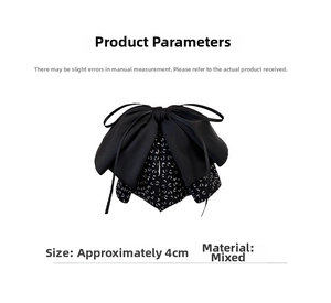 Detail view of double-layered black bow hair claw with white polka dots and size label