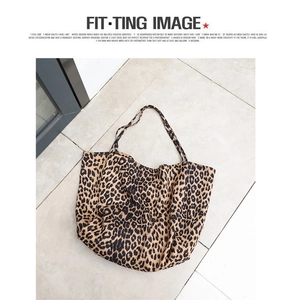 Detail of large leopard print tote bag placed on elegant grey tile flooring