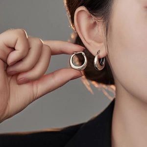 U-shaped silver geometric hoop earrings for women shown worn and in hand close-up