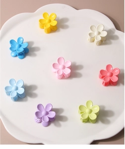 Set of eight colorful matte flower hair claws arranged on a cloud-shaped display tray