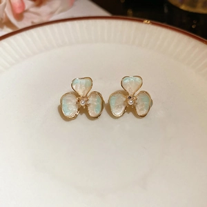 Detailed close-up of 18k gold plated acrylic flower earrings with pearl centers