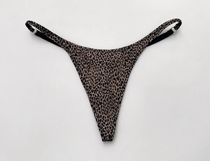 Détail d'un string T-back imprimé léopard avec boucles métalliques réglables et fines brides