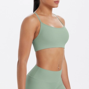 Détail de la brassière de sport vert sauge à fines bretelles et du legging à taille haute