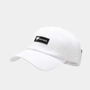 Close-up of white cotton baseball cap showing hand made embroidery and fabric texture