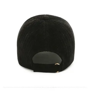 Detail of the back of a black corduroy baseball cap with an adjustable gold ring buckle