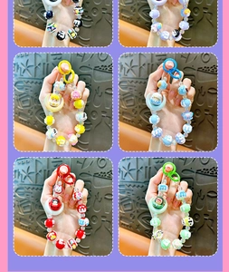 Detail showing six color variants of cute moon-shaped beaded charms for bags or phones.