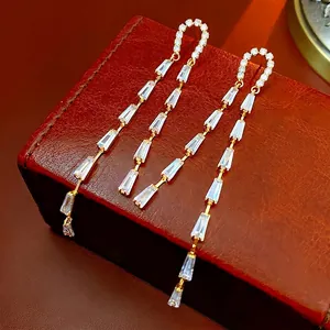 U-shaped gold fringe earrings with micro-set zircons on luxury leather jewelry box