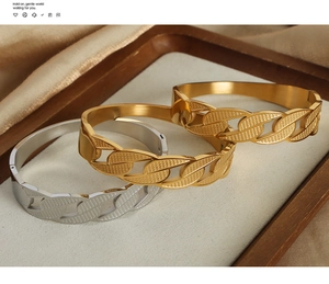 Detailed close-up of gold and silver plated chain-link embossed bangles on luxury tray