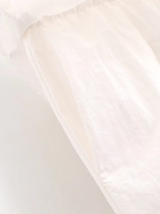 Détail d'une poche en tissu blanc montrant des coutures de haute qualité et une finition soignée