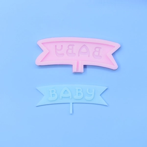 Dettaglio dello stampo in silicone rosa con scritta BABY e decorazione in pasta di zucchero