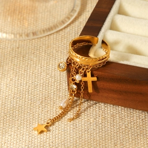Gold stainless steel star and cross charm ring with pearls on a wooden jewelry box