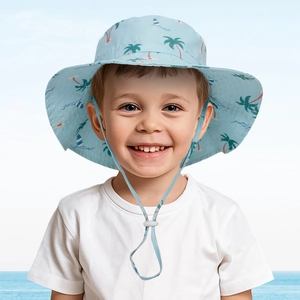 Toddler sun hat with tropical palm print and adjustable chin strap in seaside setting