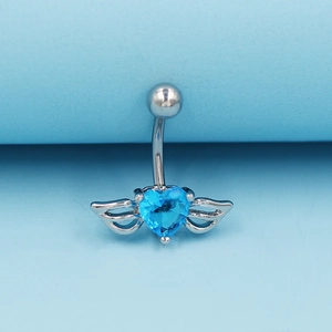 Gros plan d'un piercing nombril argenté avec un zircon bleu en cœur et des ailes
