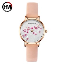 Detailed macro of a rose gold quartz watch with pink leather strap and cherry blossom dial
