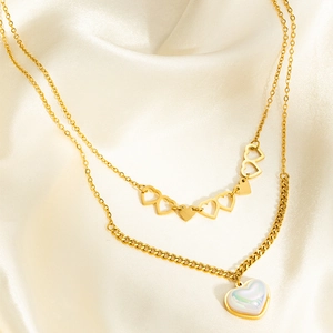 Détail d'un collier multicouche en acier doré avec pendentifs cœurs sur soie