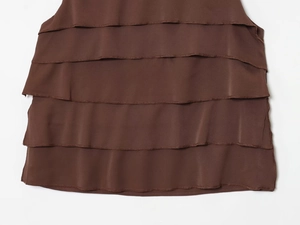 Detailed view of chocolate brown satin multi-layer ruffled edges and refined stitching