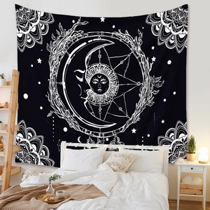 Detail of bohemian black and white astrology tapestry hanging in a cozy bedroom