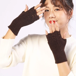 Detailed knit texture of dark brown fingerless gloves showing a stylish fish scale pattern