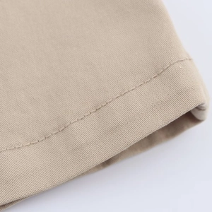 Close-up of khaki cotton twill fabric showing fine stitching and durable material texture