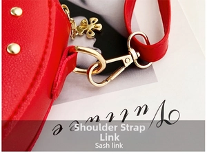 Detail of red leather bag with golden lobster clasp and flower charm accessories