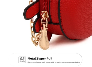 Detailed close-up of golden metal zipper and chain on the red textured leather crab bag