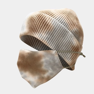 Detailed view of tie-dye knit beanie and matching face mask set with adjustable ear loops