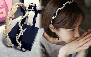 Detail of twisted headband with white pearls and sparkling crystals on fabric base