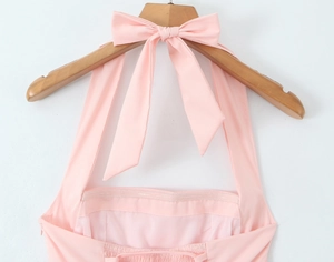 Pink halter dress detail featuring a large bow neckline and elastic pleated back detail