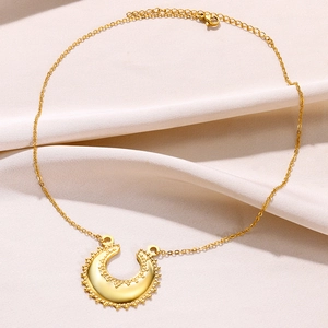 Détail du collier en acier inoxydable plaqué or 18k avec pendentif demi-lune sur tissu