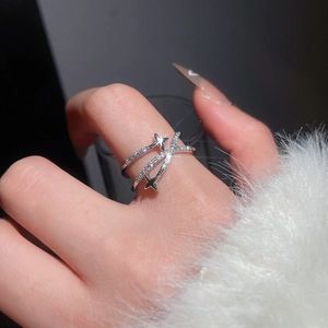 Gros plan d'une bague croisée en argent avec breloques étoiles et incrustation de zircon