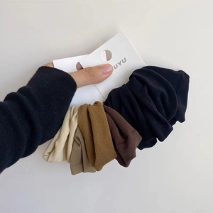 Close-up of soft seamless scrunchies in earthy tones like black and beige