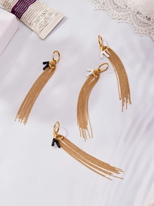Detail of 18k gold-plated long tassel earrings with black and white enamel letter charms