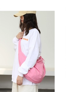 Vista laterale della modella con borsa in nylon rosa che mostra capacità e drappeggio