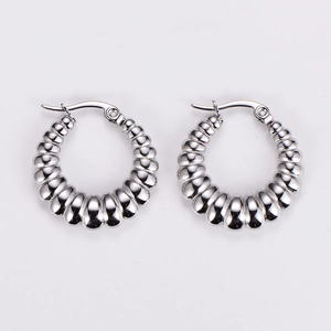 Close-up of silver-toned stainless steel hoop earrings with textured spiral design