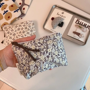 Detailed close-up of a floral cotton linen coin purse with a premium zipper and fabric tag