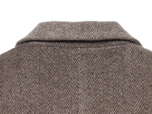 Macro shot of herringbone weave texture and shoulder seam on brown wool blend blazer