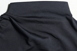 Close-up of black knit fabric texture and high collar detail of the long sleeve dress