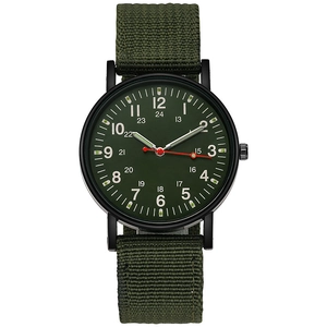 Macro detail of military-style watch featuring army green nylon strap and black metal case