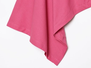 Détail du tissu rose en mélange de lin montrant la texture épaisse et les coutures