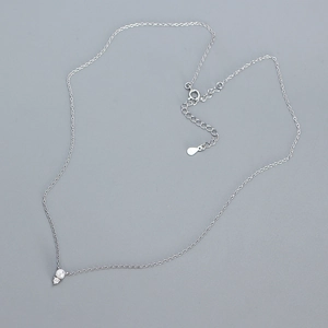 Detail of silver S925 necklace with pearl and cubic zirconia pendant on grey background