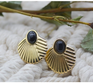 Close-up of fan-shaped 18K gold-plated stud earrings with black oval gemstone inlay