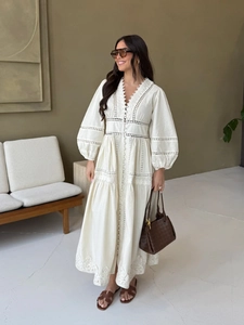 Détail d'une robe élégante à col en V avec empiècements en dentelle et broderie