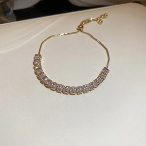 Detail of adjustable slider clasp on golden bracelet with sparkling square-cut zircons