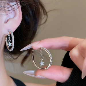 Detailed view of silver C-shaped star hoop earring with pave-set zircon stones