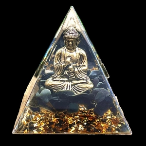 Detailed view of resin pyramid with golden Buddha statue and healing black stones