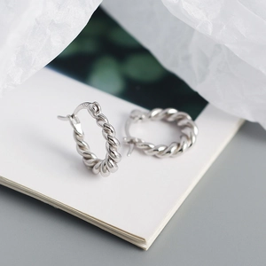 Macro shot of S925 sterling silver U-shaped hoop earrings with twisted metal texture