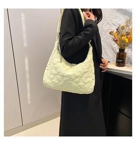 Detailed quilted star embroidery on lightweight light yellow nylon crossbody bag