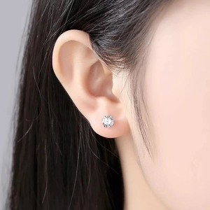 Close-up of S999 sterling silver stud earring with clear zircon on model's ear