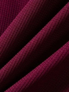 Vista macro del tessuto mesh bordeaux traspirante con trama in maglia elastica